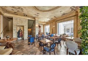 a restaurant with tables and chairs in a room at Hotel Pushkin in Tbilisi City