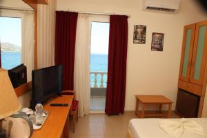 a hotel room with a bedroom with a view of the ocean at Seaside Hotel in Loutraki