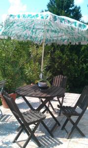 a wooden table and chairs under an umbrella at Németh Apartmanok in Zalakaros