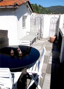 een terras met een tafel en stoelen bij Appartement de charme Arles-sur-Tech(66) in Arles-sur-Tech