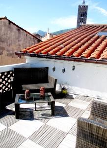 patio z kanapą i stołem na dachu w obiekcie Appartement de charme Arles-sur-Tech(66) w mieście Arles-sur-Tech