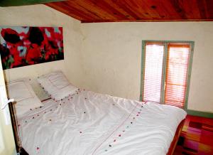 sypialnia z białym łóżkiem z czerwonymi dekoracjami w obiekcie Appartement de charme Arles-sur-Tech(66) w mieście Arles-sur-Tech