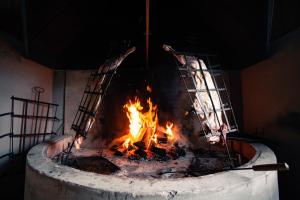 a fire in a brick oven with flames in it at Hotel Estancia Caleta Josefina in Onaisin