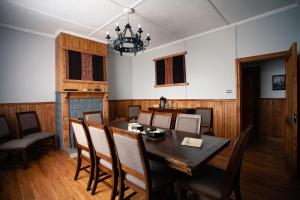 a dining room with a wooden table and chairs at Hotel Estancia Caleta Josefina in Onaisin