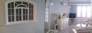 un soggiorno bianco con divano e TV di La Maison de Leo Appartamento a Massa Lubrense
