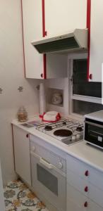 a white kitchen with a stove and a microwave at La Maison de Leo in Massa Lubrense