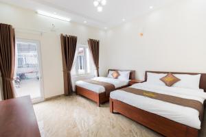 Cette chambre comprend 2 lits et une fenêtre. dans l'établissement Mỹ Kim Villa, à Đà Lạt