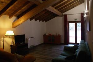 a living room with a couch and a tv at Monte do Pego in Arneiro