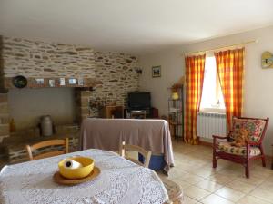 uma sala de estar com uma mesa e uma lareira em Coqueno em Sarzeau