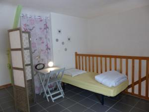 ein kleines Schlafzimmer mit einem Bett und einem Tisch in der Unterkunft Coqueno in Sarzeau