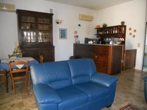 a living room with a blue couch and a table at Residence Gnura Momma in Locri