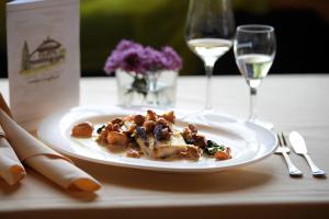 a plate of food on a table with wine glasses at Landgut Jungfleisch in Gries