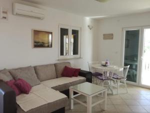 una sala de estar con un sofá y una mesa en Apartman Dora, en Povljana