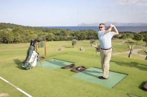 a man is standing on a golf course at Blu Hostal Diana in Port d'Alcudia