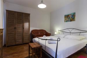 a bedroom with a bed and a leather chair at Apartment Hladilo "Nostalgia" in Dubrovnik