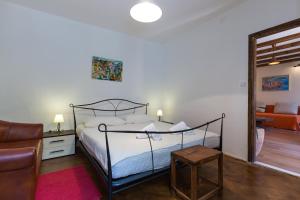 ein Schlafzimmer mit einem Bett, einem Stuhl und einem Sofa in der Unterkunft Apartment Hladilo "Nostalgia" in Dubrovnik