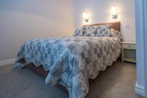 1 dormitorio con 1 cama con manta azul y gris en Stay en Blackpool