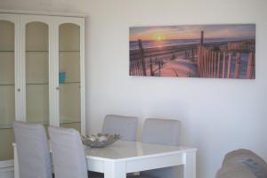 a dining room with a white table and chairs at Ericeira Sunset Apartment in Ericeira
