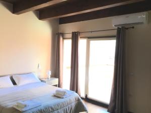 um quarto com uma cama e uma grande janela em B&B Nonna Maria em Lamezia Terme