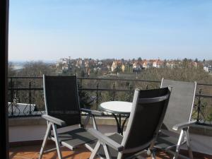 three chairs and a table on a balcony with a view at Ferienwohnung mit tollem Ausblick in Dresden