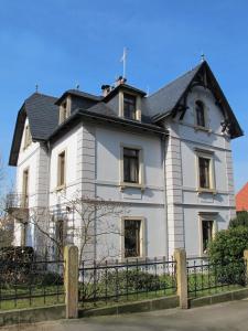 a large white house with a black roof at Ferienwohnung mit tollem Ausblick in Dresden