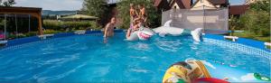 a group of children playing in a swimming pool at U Beaty in Frydman