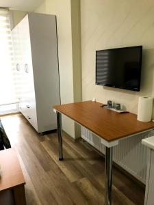 um quarto com uma mesa e uma televisão de ecrã plano em Ada Residence em Karamamaras