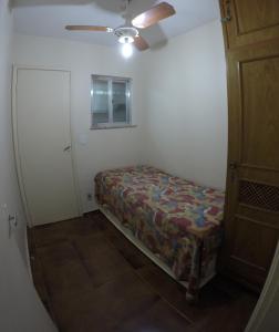 une petite chambre avec un lit et un ventilateur de plafond dans l'établissement Praia do Forte: 5 min a pé, à Cabo Frio