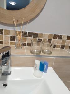 zlew w łazience ze szczoteczkami do zębów i okularami na blacie w obiekcie Cosy & Stylish apartment with a priceless view w Kapsztadzie