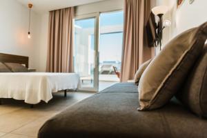 een hotelkamer met een bed en een groot raam bij Apartamentos ZHR in Zahara de los Atunes