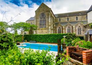 eine Kirche mit einem Pool vor einem Gebäude in der Unterkunft la maison d'idylle in Combourg + 7 Fotos