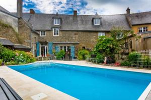 a swimming pool in front of a house at la maison d'idylle in Combourg