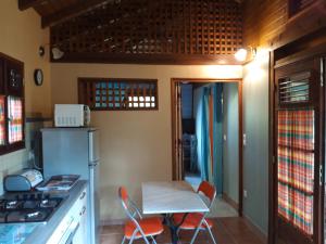cocina con mesa y sillas en una habitación en Les Fougères, en Baie-Mahault