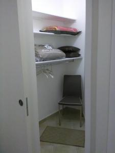 a chair sitting in a closet with a shelf at Elisea House in Oria +2 photos