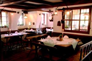 a dining room with tables and chairs and windows at Pilgerhaus Bergen in Neuburg an der Donau