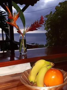 eine Schale Bananen und Orangen auf dem Tisch in der Unterkunft Les Gîtes Kajou in Bouillante