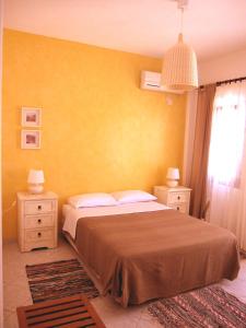 1 dormitorio con 1 cama, 2 mesitas de noche y ventana en Ariston Apartments, en Serifos Chora
