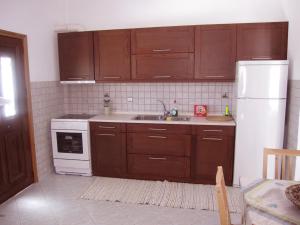 セリフォス・ホラにあるAriston Apartmentsのキッチン(木製キャビネット、白い冷蔵庫付)