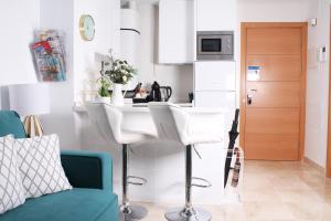 a kitchen with a white counter and a blue couch at Ancha del Carmen AVE Centro Málaga madmar lujo New Zambrano in Málaga