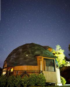 una casa redonda con techo abovedado por la noche en Turismo del Bosque en Castro