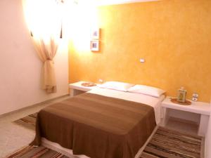 a small bedroom with a bed and a sink at Ariston Apartments in Serifos Chora