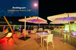 a patio with tables and chairs and umbrellas at Wakanoura Nature Resort Epicharis in Wakayama