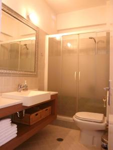 a bathroom with a sink and a toilet and a mirror at Ariston Apartments in Serifos Chora