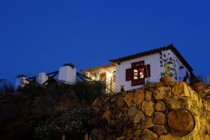a house sitting on top of a stone wall at Finca Los Ciruelos Casas Rurales in Icod de los Vinos