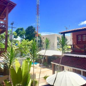 塔曼達雷的住宿－熱帶海岸酒店，享有棕榈树和遮阳伞的城市美景。