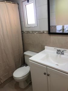 a bathroom with a toilet and a sink and a mirror at Carl's Unique Inn & Conference Facilities in Simpson Bay