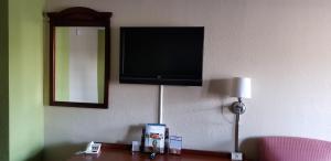 - une télévision à écran plat suspendue au mur dans une chambre d'hôtel dans l'établissement Newport News Inn, à Newport News