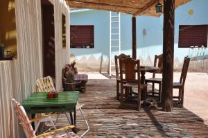 a group of chairs and tables on a porch at Hospedaje Familiar Raza Mistica in Villa Unión