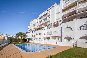 an apartment with a swimming pool in front of a building at Sea View Downtown - Albufeira in Albufeira