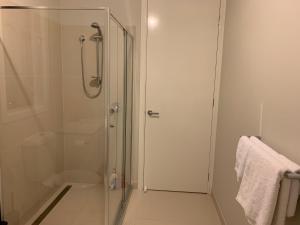 a shower with a glass door in a bathroom at Apple House Truganina in Truganina